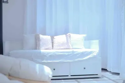 a white bed with four pillows on top of it at Comfy Sofy 23- Balcony Garden (Night market) in Tanah Rata