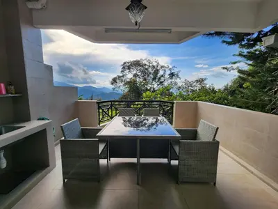 a patio with a table and chairs on a balcony at Little England B3 in Bukit Fraser