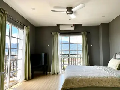 a bedroom with a bed and a television and windows at High floor Mountain view Kampar in Kampar