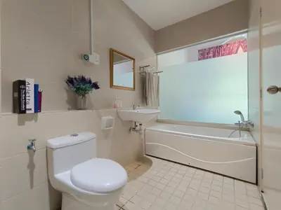 a white bathroom with a toilet and a sink at The Ipoh All Suite Resort, Jalan Haven Ipoh in Ipoh