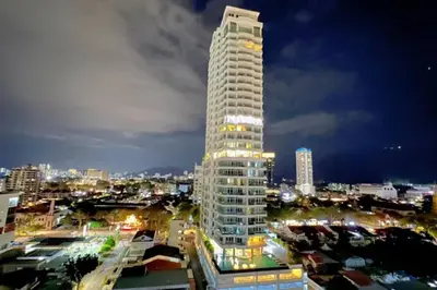 a tall white building in a city at night at Sunrise@Gurney Spacious 2BR Duplex in George Town