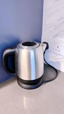 a silver pot sitting on a counter next to a bed at Sunrise@Gurney Spacious 2BR Duplex in George Town
