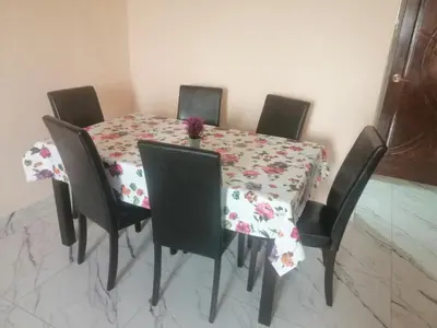 a dining room table with a floral table cloth at Zulcity Homestay in Gelugor
