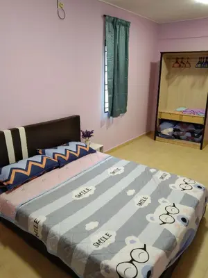a bedroom with a large bed with a blue comforter at QQ Homestay in Ipoh
