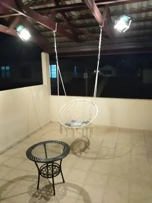 a swinging chair and a table in a room at QQ Homestay in Ipoh