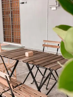 a wooden picnic table and a bench in a room at Venice Guest Hostel - Bilik Sahaja in Lumut