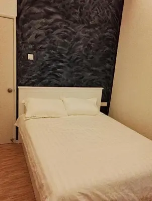 a white bed in a bedroom with a painting on the wall at Cameron Lovely Home 3 Rooms in Tanah Rata
