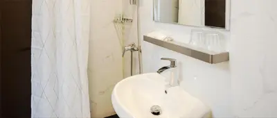 a white bathroom with a sink and a shower at SPRINGHILL RESORT in Cameron Highlands