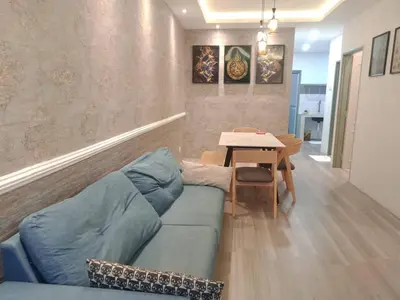 a living room with a blue couch and a table at Muslim Homestay blue Adik Aisyah Apartment in Tanah Rata