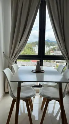 a table and chairs in a room with a window at Lily Ville in Tanah Rata