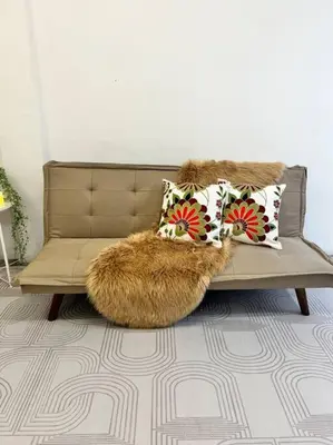 a living room with a couch with pillows on it at Roemah lily studio in Tanah Rata
