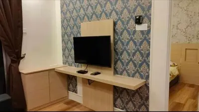 a room with a desk with a television on a wall at Cameron Homestay klasik Adik Aisyah in Cameron Highlands