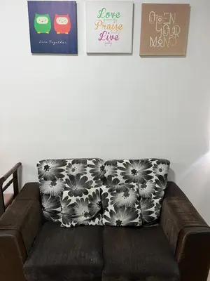 a couch in a living room with three pictures on the wall at Izwana Muslim Homestay in Tanah Rata