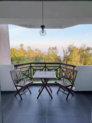 a table and two chairs on a balcony with a view at Fraser Hill Silverpart Resort A3-1-1 Forest View With Lift in Bukit Fraser