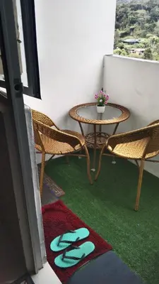a patio with a table and chairs and a green rug at Emily Homestay Cameron Highlands in Tanah Rata