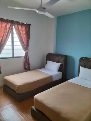 a bedroom with two beds and a window at KHAIRUL HOMESTAY PANGSAPURI SUTERA SEBERANG JAYA in Kampong Telok
