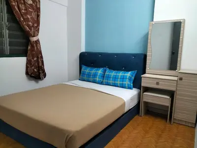 a small bed with a blue headboard in a room at KHAIRUL HOMESTAY PANGSAPURI SUTERA SEBERANG JAYA in Kampong Telok