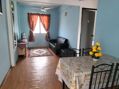 a living room with a table and a couch at KHAIRUL HOMESTAY PANGSAPURI SUTERA SEBERANG JAYA in Kampong Telok