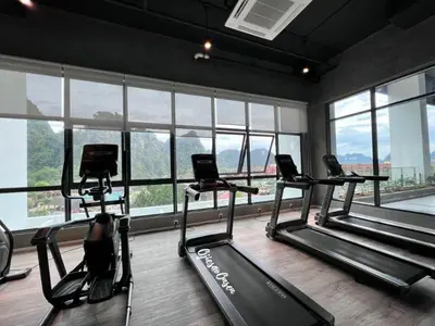 a gym with three exercise bikes in a room with windows at Ojies Onsen - 3 guest only in Ipoh