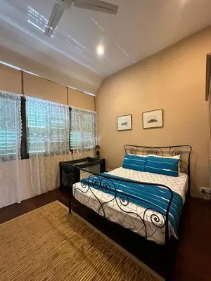 a bedroom with a bed with blue pillows and a window at Popus Heritage Townhouse, Georgetown in George Town