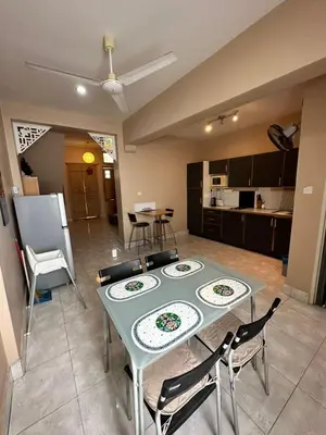 a living room with a table and chairs and a kitchen at Popus Heritage Townhouse, Georgetown in George Town