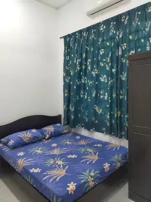 a bed in a room with a blue curtain at Kerian Putra Muslimstay in Parit Buntar