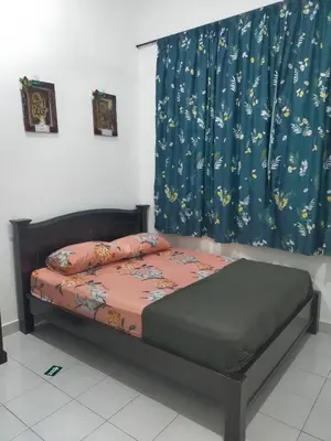 a bed in a room with a window with a curtain at Kerian Putra Muslimstay in Parit Buntar