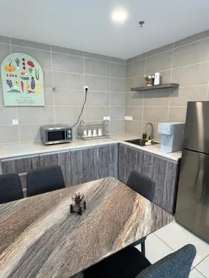 a kitchen with a table with chairs and a refrigerator at Onsen Suits HJM @ Sunway Ipoh in Ipoh