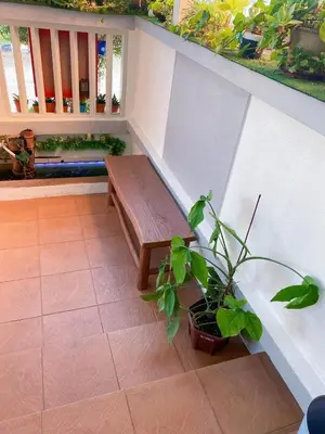 a wooden bench on a porch with a potted plant at Nautilus Bay Home Inn in George Town