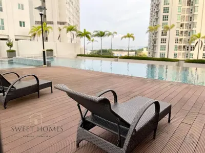 a patio with two chairs and a table next to a pool at HolidayCozy StraitsGardenSuite Penang#6pax#family in George Town