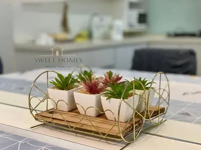 a group of plants on a wooden tray on a table at HolidayCozy StraitsGardenSuite Penang#6pax#family in George Town