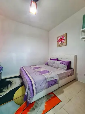 a bedroom with a bed and a painting on the wall at Amrich Staycation Muslim Cameron Highlands in Tanah Rata