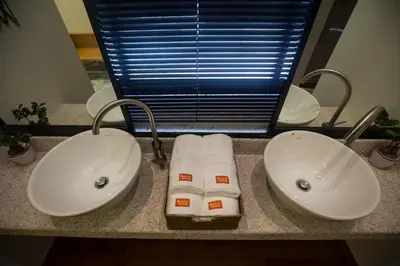 a bathroom with two sinks and towels on a counter at Carrot Seed in Ipoh