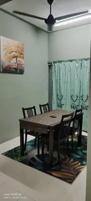 a wooden table and chairs in a room with a painting at Homestay Lumut Perak 2026 in Lumut