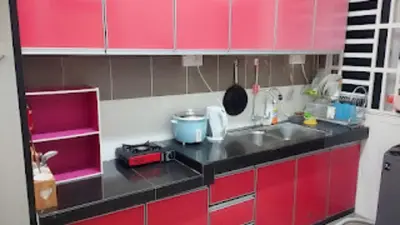 a small kitchen with red cabinets and a sink at Homestay Hafiy Manjung Lekir Sitiawan in Lekir