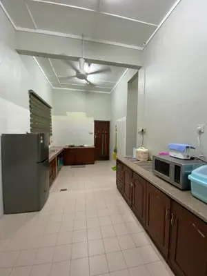 a large kitchen with a refrigerator and a microwave at Nur Kasih Homestay Seri Manjung in Seri Manjung