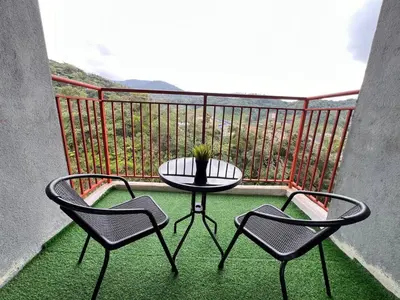 a table and two chairs on a balcony with a table at Aufa Homestay at Emerald Avenue Brinchang in Brinchang