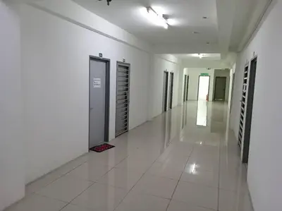 a hallway of a building with white floors and doors at Studio House Kampar in Kampar