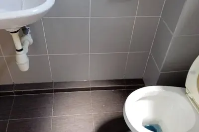 a bathroom with a white toilet and a sink at Studio House Kampar in Kampar