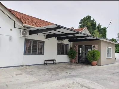 a white house with a bench in front of it at Raintown inn taiping in Taiping
