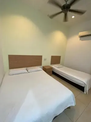 a bedroom with two beds and a ceiling fan at Raintown inn taiping in Taiping