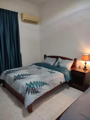 a bedroom with a bed and a table with a lamp at Sofea Inn Bukit Merah - Suria A7727 in Kampong Selemat