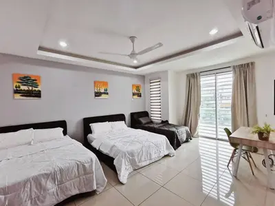 a bedroom with two beds and a table and a window at Botani Tmn Cyber Ipoh(24 pax /tv box/mahjong) in Ipoh