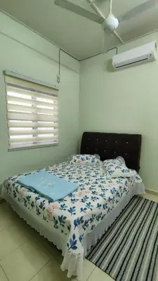 a bedroom with a bed with a blue comforter at Che Det Homestay Chemor in Chemor