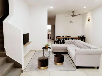 a living room with a white couch and a table at Bdr Seri Botani ipoh-nordic (tvbox/mahjong 19pax) in Ipoh