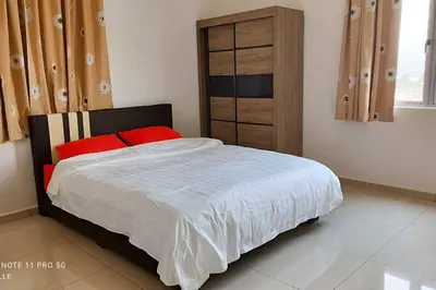 a bedroom with a bed with red pillows and a wooden cabinet at Spaces 3bed Room New Condo @ Kg Paloh Ipoh in Ipoh