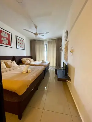a bedroom with two beds and a television in it at Paddy Bee in Brinchang