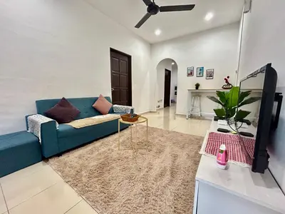 a living room with a blue couch and a table at Cozy288#4pax#wifi#NearAeonAlma,Mcd#2kmtoIconicPoint in Bukit Mertajam