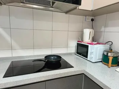 a kitchen with a stove with a frying pan on it at The Sun 1 or 3BR Bayan Lepas 4 to 10 pax WL in Bayan Lepas