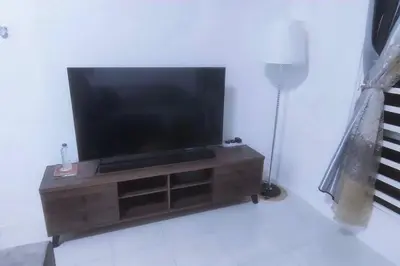 a flat screen tv sitting on top of a wooden entertainment center at Homestay Millazzz Apparment Ipoh in Kampong Duson Gilap